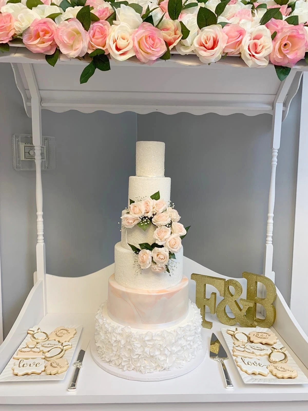 6 tier white wedding cake with pink accent 5th tier and pink florals