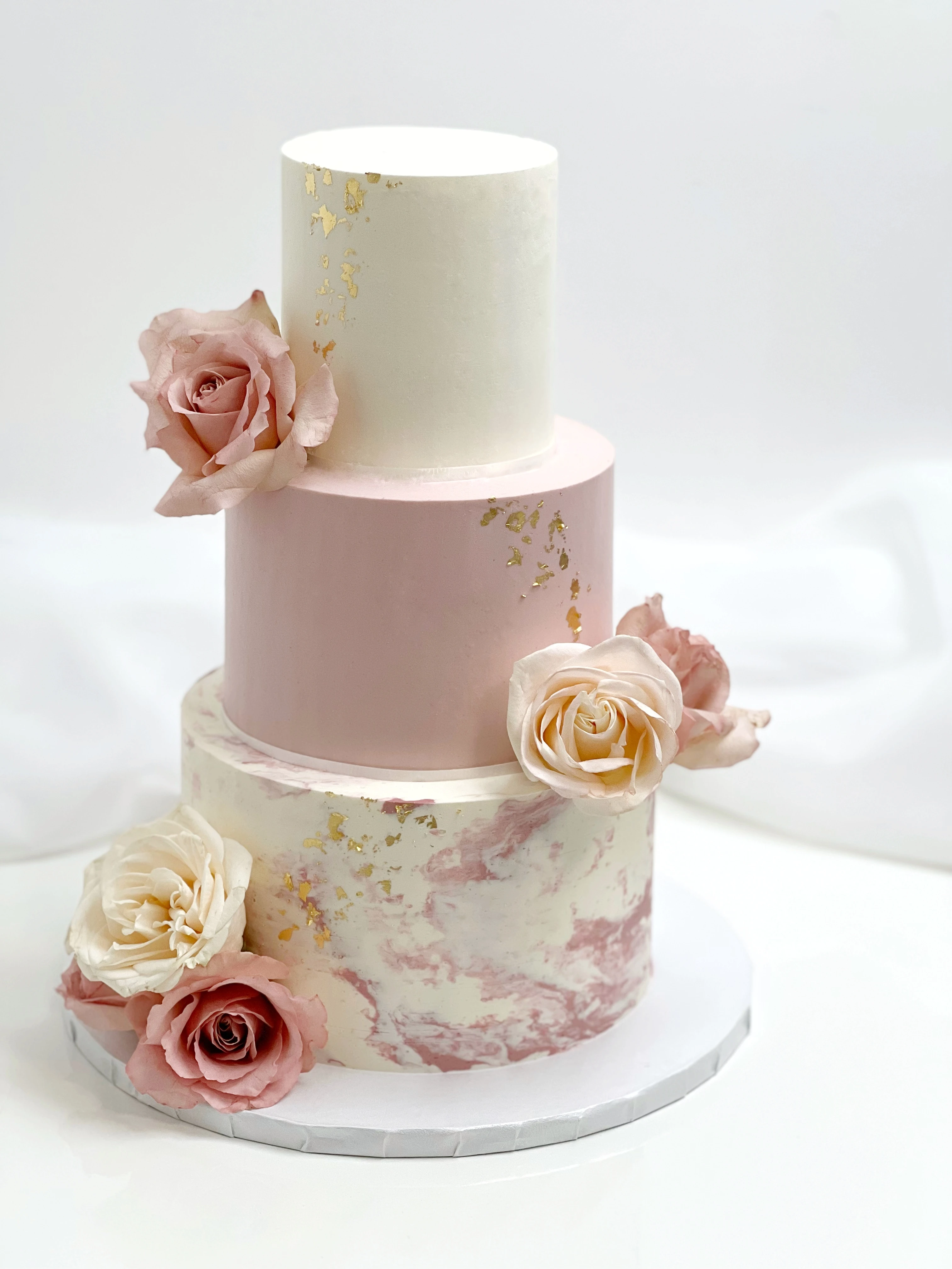 3 tier white and pink florals and marbled wedding cake