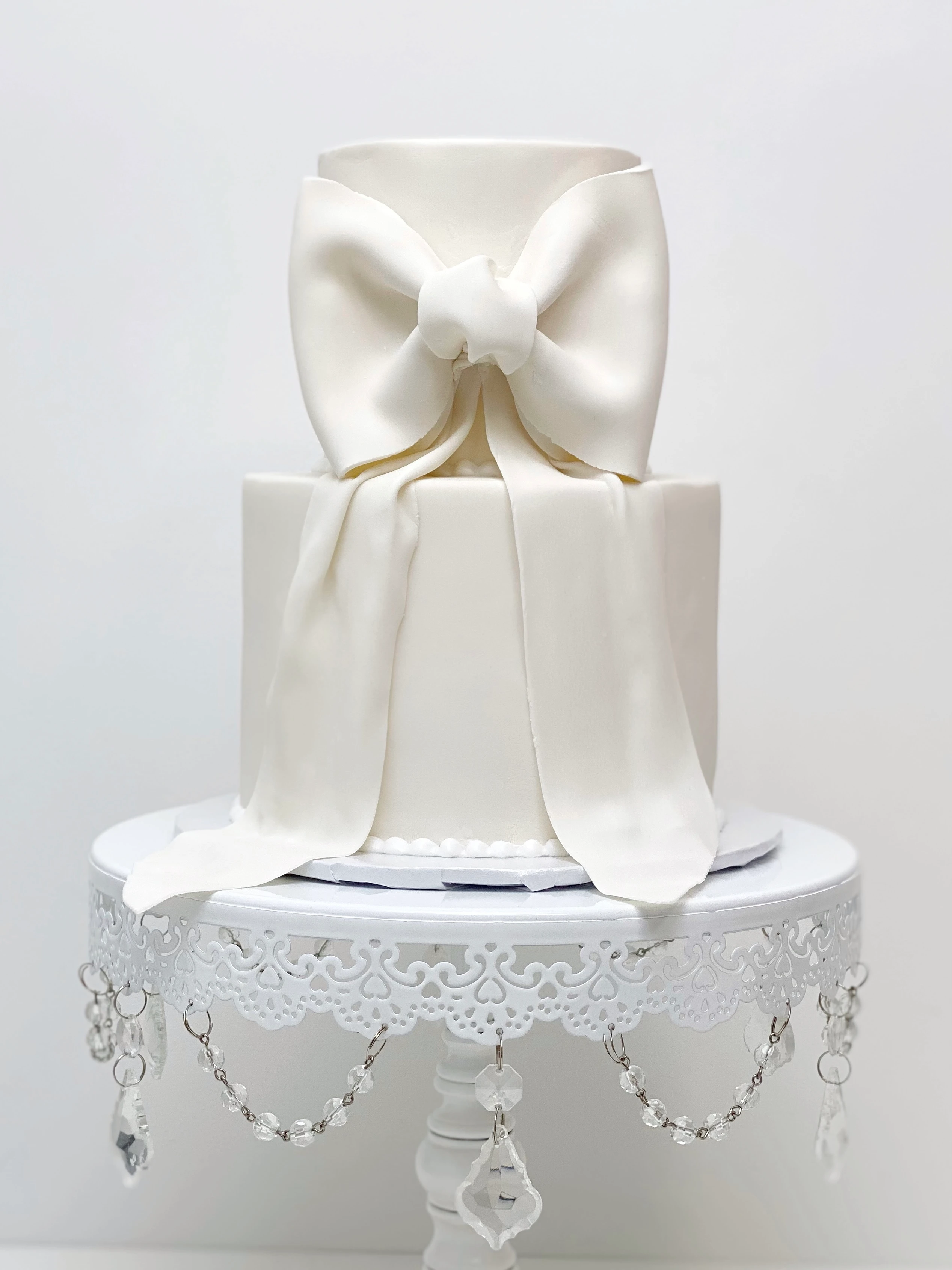 White ribbon cake on a white cake stand