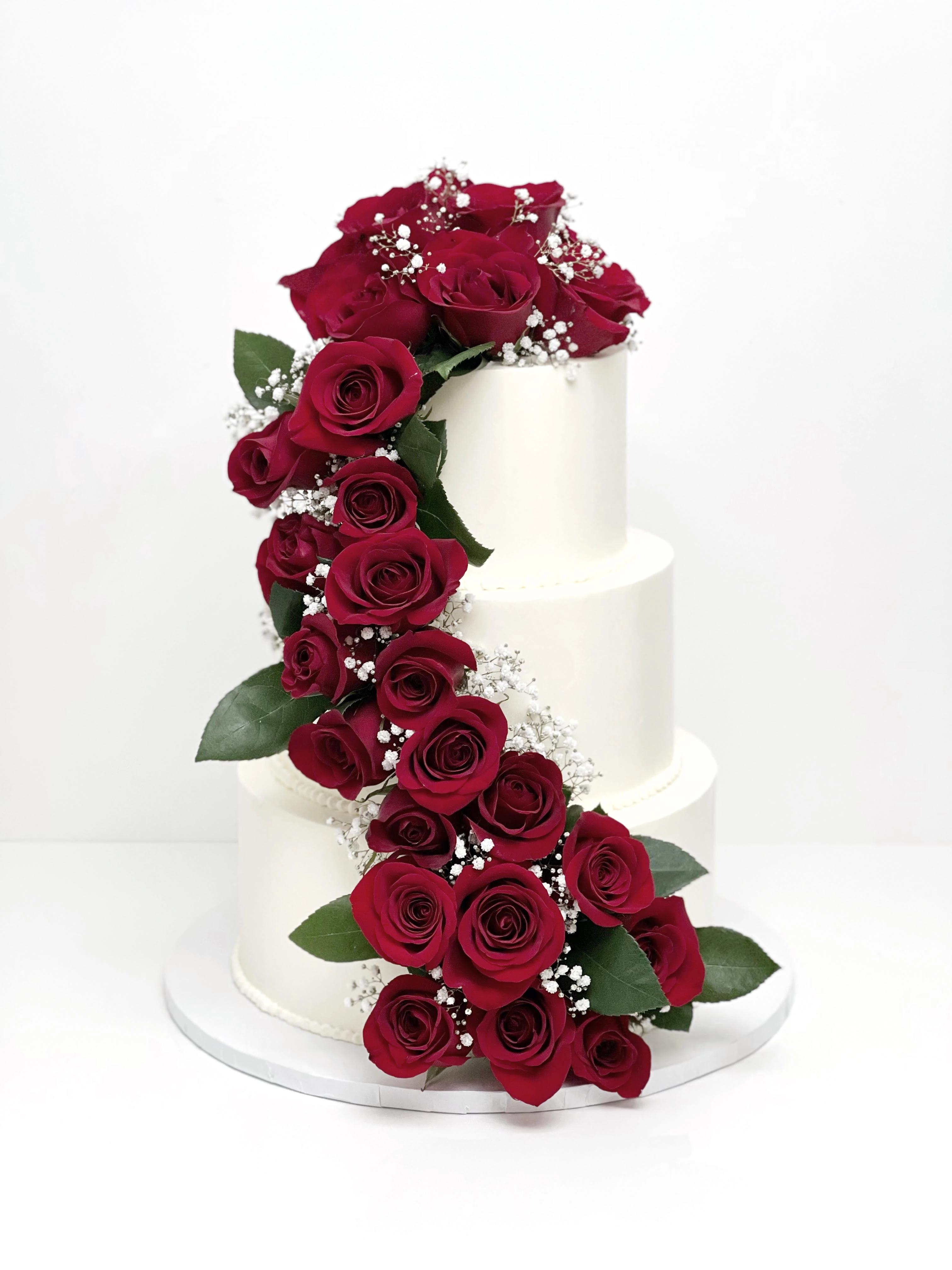 3 tier white wedding cake with diagonal red roses